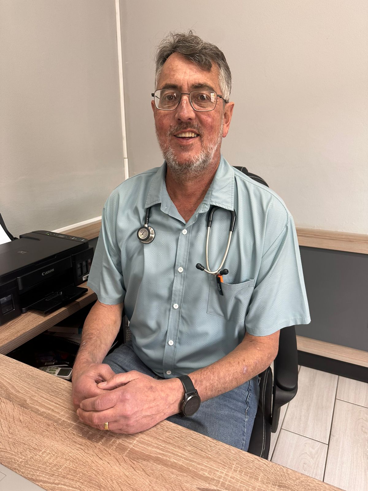 Dr. Jaco Sadler seated in consultation room